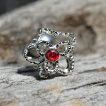 Piercing cartilage tragus hélix à fleur ajourée avec strass rouge